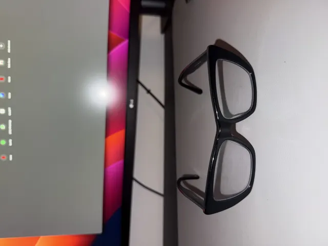 A phone photo to avoid: black glasses on a desk next to a monitor