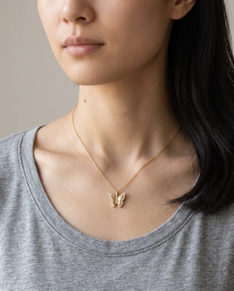 The butterfly pendant worn with a grey tee, generated