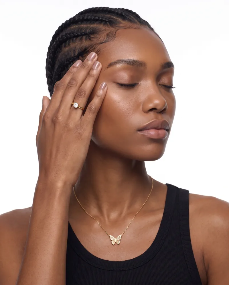 A butterfly pendant necklace worn by a cast model — a launch hero