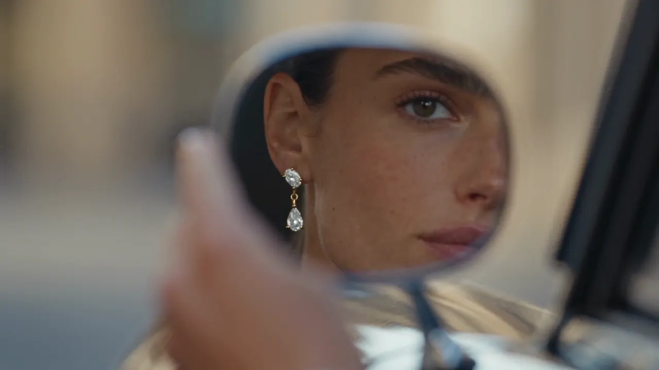 Frame of a Cheeppy product film: an earring seen in a car mirror